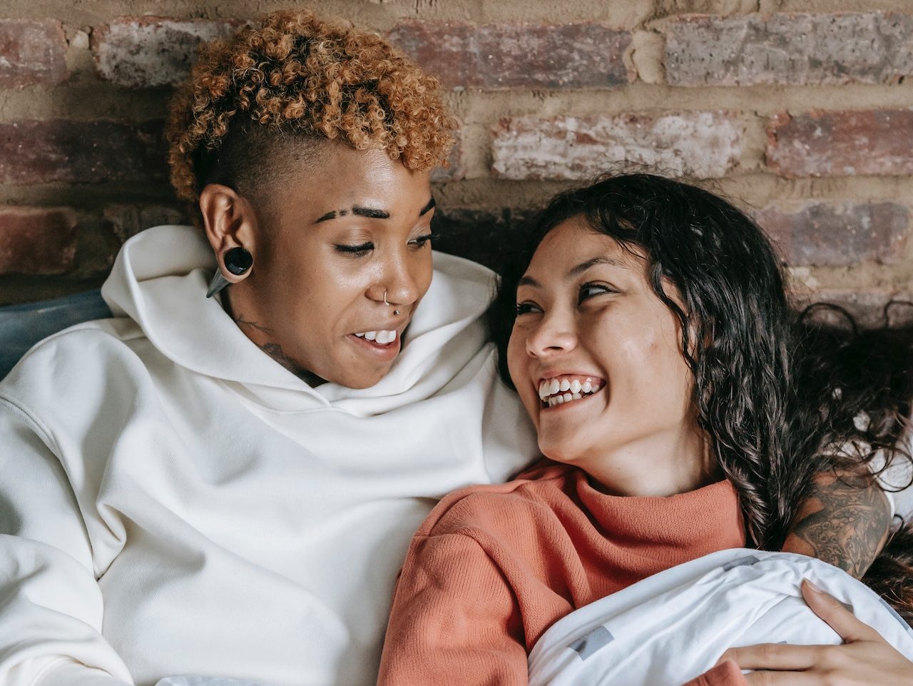 Two women smiling at each other, their relationship has improved after LGBTQ counseling.