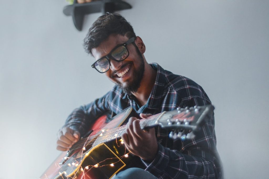 Man playing guitar with increased self-esteem.