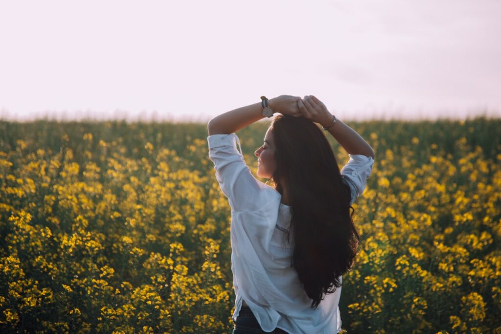 Woman smiling in field after overcoming depression.