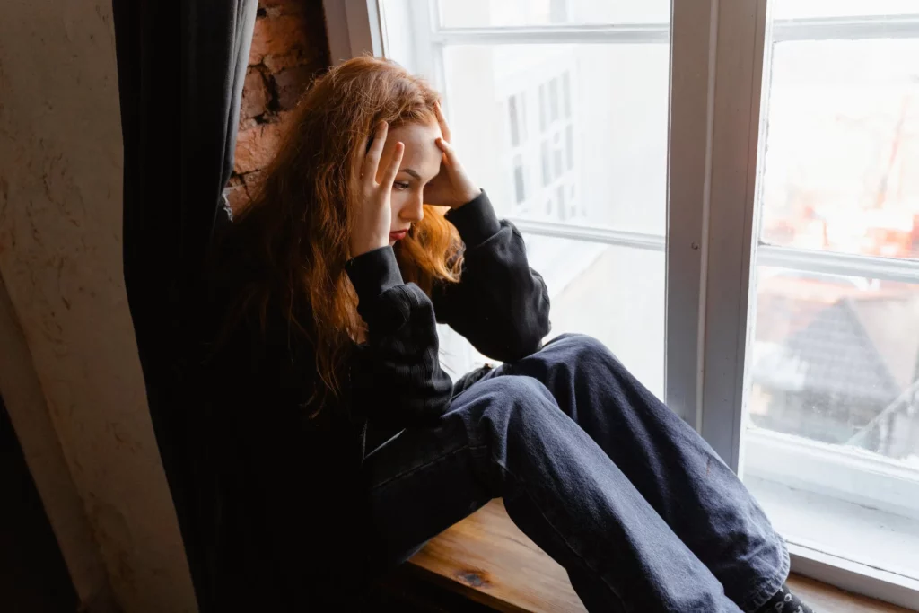 Sad woman at window with seasonal affective disorder